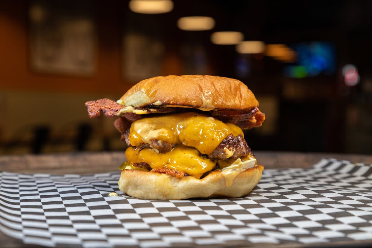 The Classic - Two American Wagyu beef patties, bacon, cheddar cheese, diced onions, pickles, Foxtrot sauce served on a Martin's potato bun.