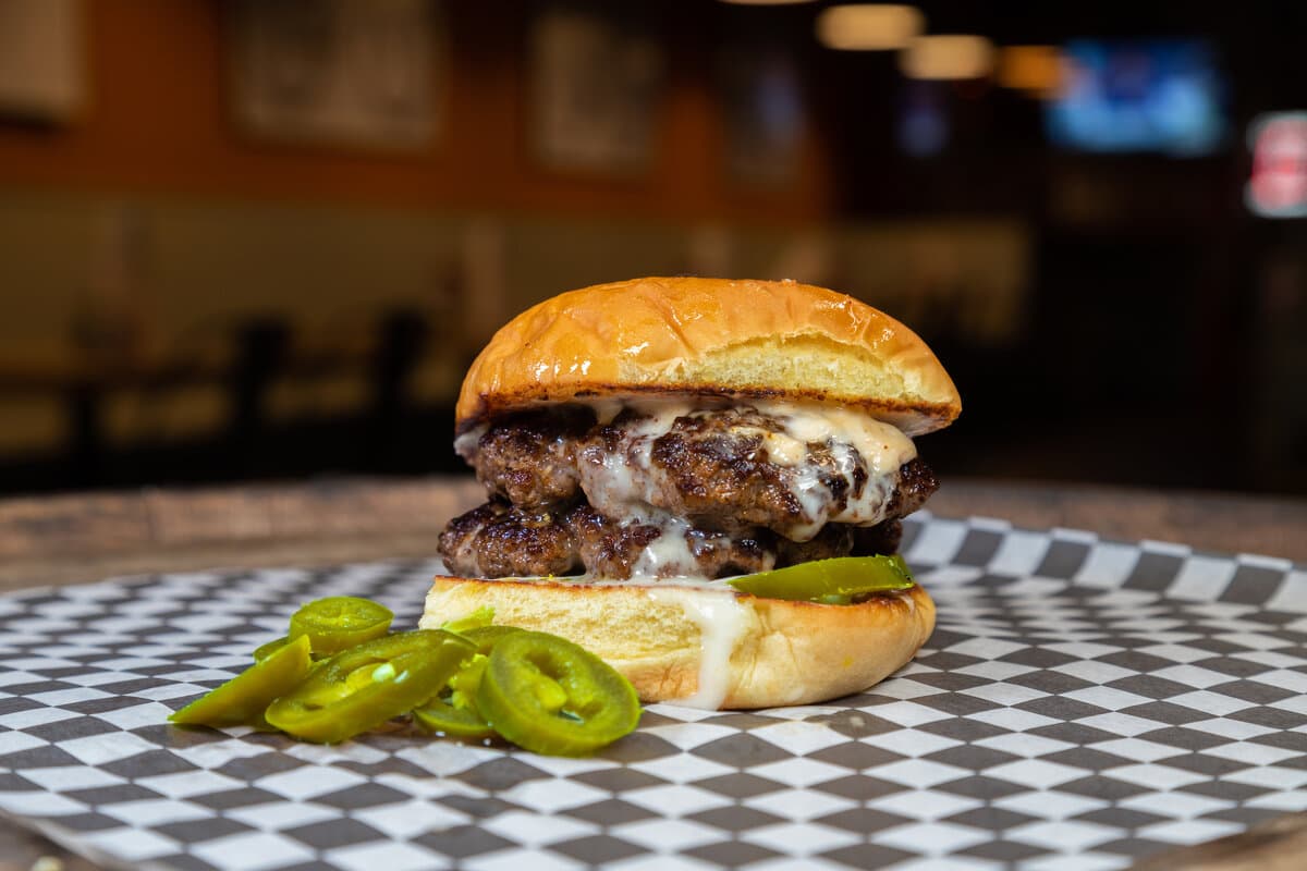 Queso Blanco - Two patties, queso dip, jalapeños and a chipotle aioli for a kick of flavor.