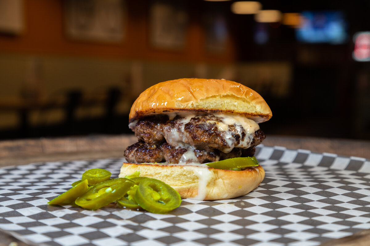 Queso Blanco - Two patties, queso dip, jalapeños and a chipotle aioli for a kick of flavor.
